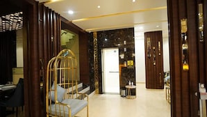 A hotel lobby with a gold-framed chair, a staircase, and a marble wall. - Fabhotel Prime Orange Tree (Nagpur)