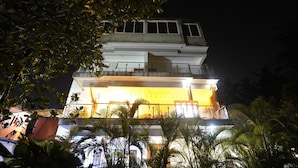 A multi-story building with a balcony and a lit interior. - FabHotel The Sky - Nr. Calangute Beach (Calangute)