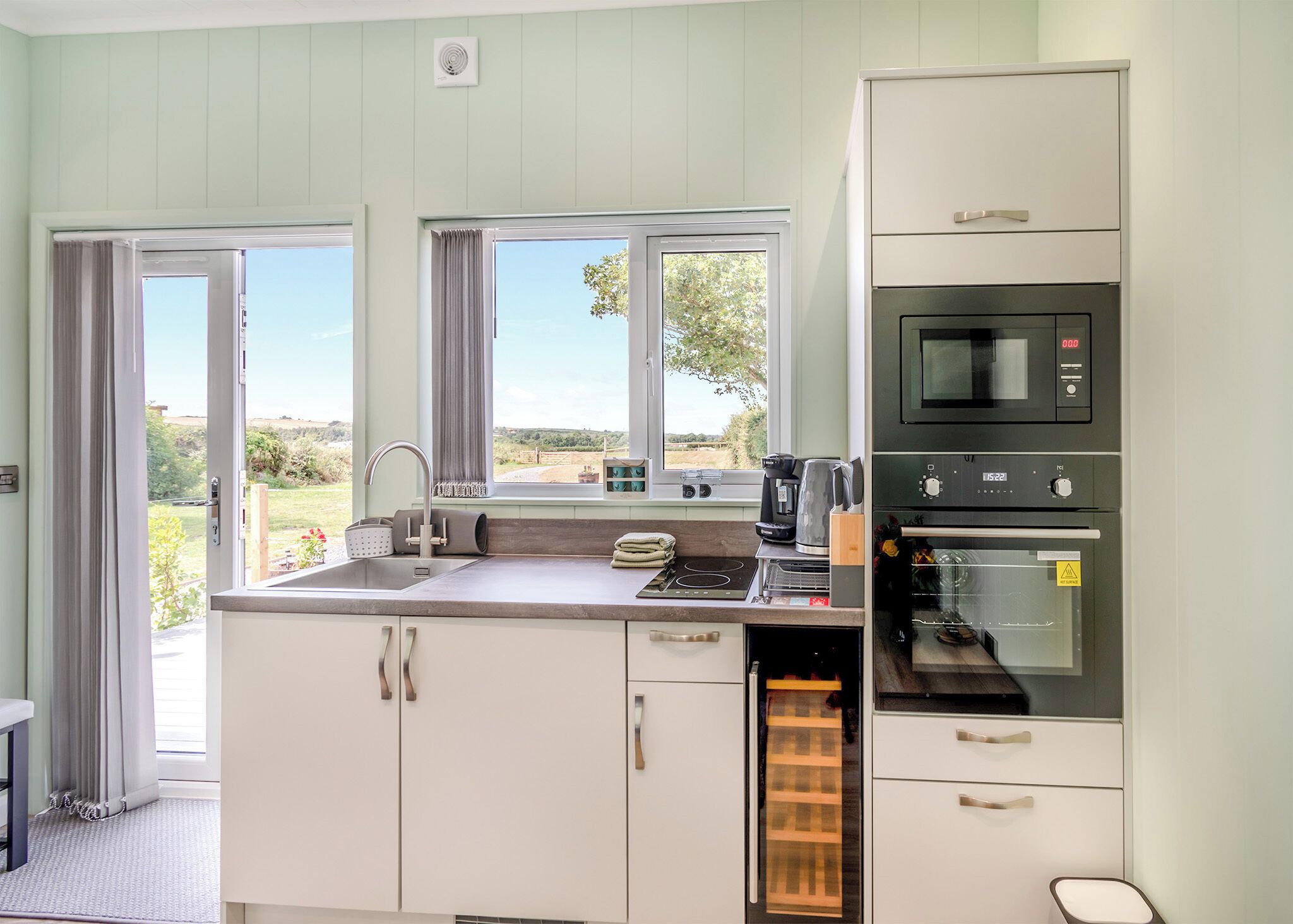 A kitchen with a view, a sink, a coffee maker, and an oven.