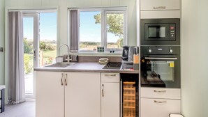 Une cuisine avec vue, un évier, une machine à café et un four.