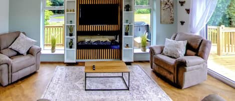 Ein Wohnzimmer mit zwei Sofas, einem Couchtisch und einer TV-Wand.