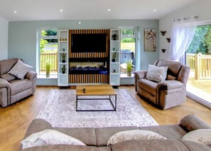 Ein Wohnzimmer mit zwei Sofas, einem Couchtisch und einer TV-Wand.