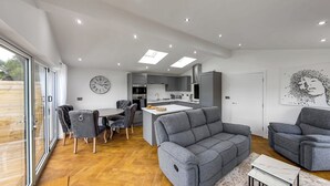 A modern living space with a dining area, sofa, and kitchen. - Superb bespoke lodge with two bedrooms sleeping up to four people. (Laceby)