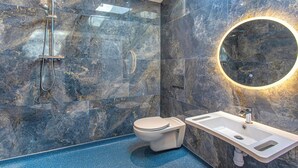 A modern bathroom with a marble wall, a glass shower enclosure, a toilet, and a sink with a mirror. - Superb bespoke lodge with two bedrooms sleeping up to four people. (Laceby)