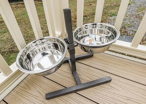 A metal dog bowl stand on a wooden deck. - Large 12ft-wide caravan with one double with en suite W. (Cardigan)