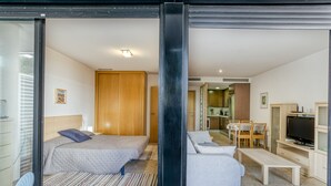 Une chambre d’hôtel moderne équipée d’un lit, d’un canapé, d’une télévision et d’un coin repas.