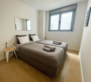 A bedroom with two beds, a small bedside table, a mirror, and a window. - Apartment 'Frontline Duna Beach' with Sea View, Wi-Fi and Air Conditioning (Torrox costa)