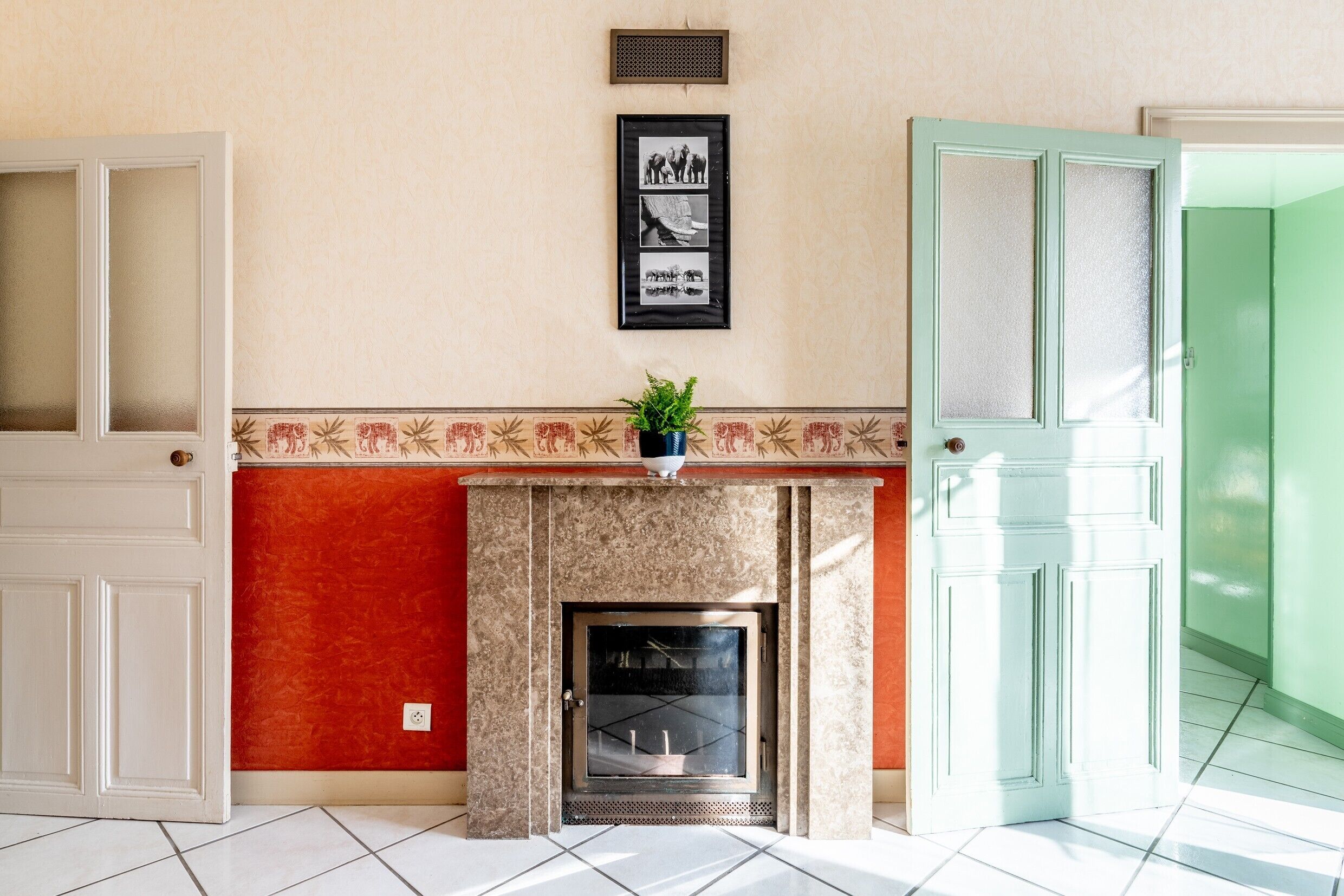 A room with a fireplace, a framed picture on the wall, and a door.