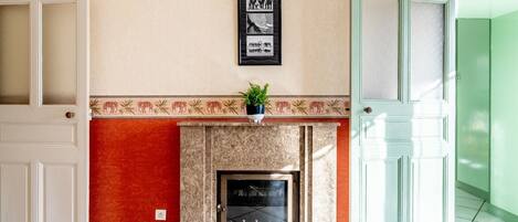 A room with a fireplace, a framed picture on the wall, and a door.