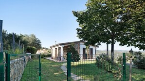 A fenced property with a pathway leading to a building, surrounded by greenery and a clear sky. - Apartment "La Casa di Lele" with Sea View, Private Garden and Wi-Fi (Costarainera)