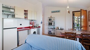A compact living space with a kitchenette, a dining area, and a bed. - Apartment "La Casa di Lele" with Sea View, Private Garden and Wi-Fi (Costarainera)
