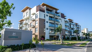 A multi-story residential building with a sign reading "CANAMAR RESIDENCES."