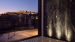 Un interior modern amb una finestra gran que mira un edifici històric a l'hora del crepuscle.