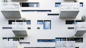 A modern building with multiple balconies and a patterned facade.