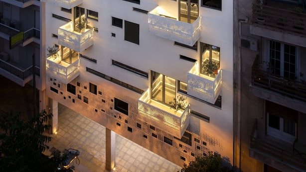 A modern multi-story building with balconies and large windows.
