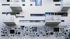 Een modern gebouw met meerdere balkons en een decoratief gevelontwerp.