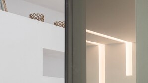 A modern bedroom with a bed, a wooden staircase, and a door with a round handle. - Family Maisonette, Urban Stripes Athens (Athens)