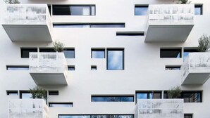 A modern building with multiple balconies and a patterned facade.