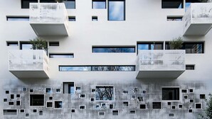 A modern building with multiple balconies and a perforated facade. - Acropolis Maisonette, Urban Stripes Athens (Athens)