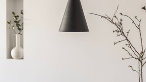 A dining table with plates of food, a vase with branches, and a black pendant light. - Acropolis Maisonette, Urban Stripes Athens (Athens)