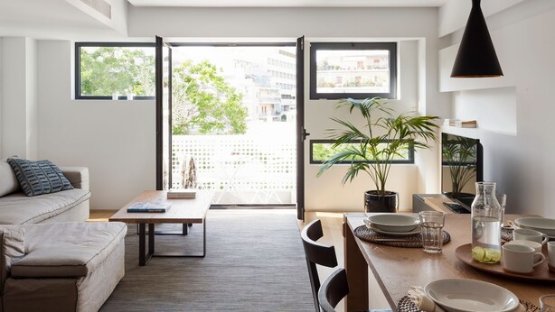 A modern apartment with a dining area, a sofa, and a large window offering a view of the city. - Acropolis Maisonette, Urban Stripes Athens (Athens)