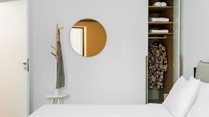 A bedroom with a bed, a round mirror, a coat rack, and a wardrobe. - Acropolis Maisonette, Urban Stripes Athens (Athens)