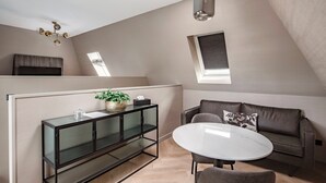A modern living room with a glass console table, a round white table, and a brown leather sofa. - Breathe Boutique hotel Leiden (Leiden)