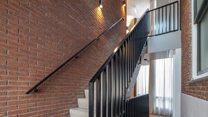 A staircase with a brick wall and metal railings. - Breathe Boutique hotel Leiden (Leiden)