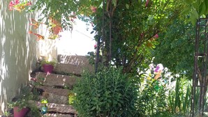 Una escalera de piedra rodeada de macetas con plantas y flores.