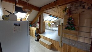 Una cocina rústica con vigas de madera, un tragaluz y un árbol de Navidad.