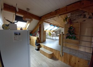 Una cocina rústica con vigas de madera, un tragaluz y un árbol de Navidad.