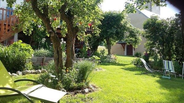 Un jardín bien cuidado con césped, árboles y un pequeño edificio.