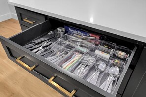 A drawer with neatly organized kitchen utensils and supplies, including plastic containers, a box of Reynolds Wrap, and a bottle of dish soap. - Fire Pit - Grill - Hammock - King Bed 🏡 3BED/2BA 1 Story Home (The Woodlands)