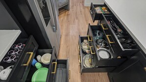 A kitchen with multiple drawers containing various kitchenware and utensils. - Fire Pit ☀️ Grill - Hammock - King Bed 🏡 1 Story Home (The Woodlands)