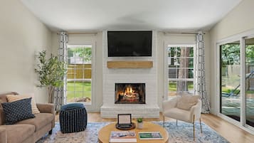 A living room with a fireplace, a sofa, a chair, and a coffee table.