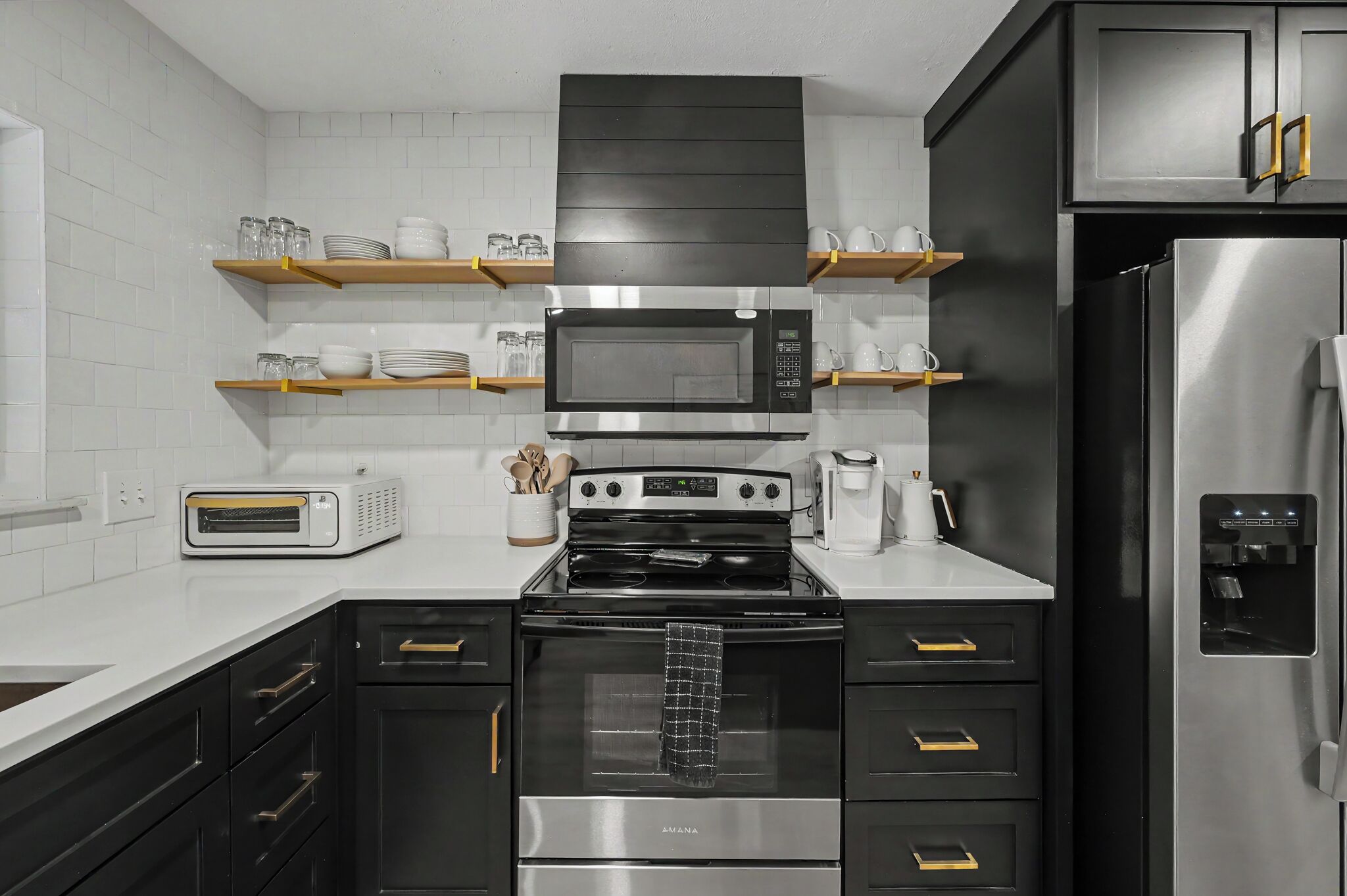A modern kitchen with a built-in microwave, oven, and refrigerator.