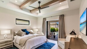 Un dormitorio moderno con cama, mesitas de noche, un escritorio y una silla.