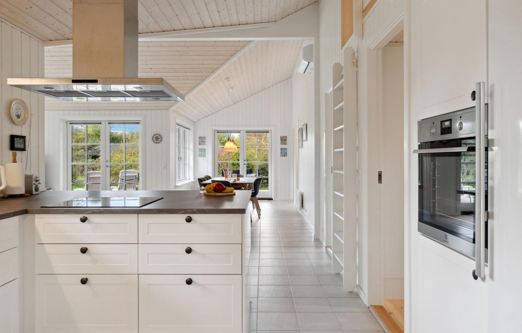 Een moderne keuken met witte kasten, een centraal eiland en een inbouwoven.