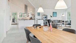 A spacious kitchen with a large island, a dining area with a wooden table, and a living space with a sofa and chairs. - Awesome home in Græsted with WiFi (Græsted)