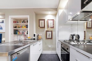 Una cocina moderna con lavavajillas integrado, cafetera y estufa a gas.