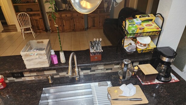 A kitchen with a stainless steel sink, a coffee maker, and a knife block. - Texas Motor Speedway Comfort Zone (Justin)