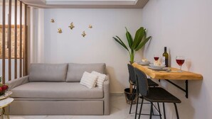 Ein stilvoller Wohnraum mit einer Couch, einem Esstisch, Stühlen und Wandkunst.