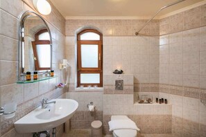Ein Badezimmer mit Waschbecken, Spiegel, Fenster, Dusche und Toilette.