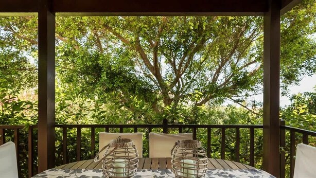A covered outdoor seating area with a table and chairs, surrounded by lush greenery. - Argo Luxury Villa (Iason Villas), 3 Bedrooms (Maleme)