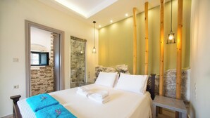 Une chambre à coucher avec un lit, un banc, un mur en bois et un luminaire suspendu.