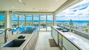 A modern kitchen with a large island, a sink, and a view of the ocean. - La Jolla Dream Stay: Ocean, Bay, Pool (San Diego)