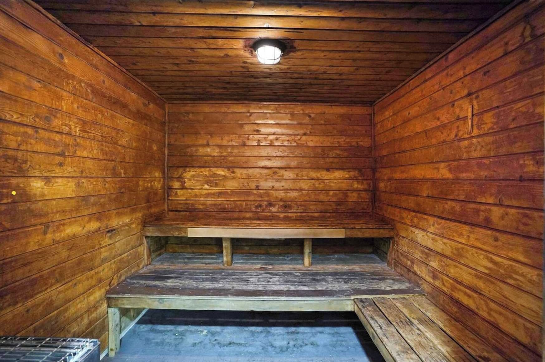 Eine Holzsauna mit einer Sitzbank und einem kleinen Fenster.