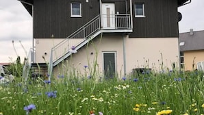 Een gebouw met twee verdiepingen, een balkon en een trap naar de bovenverdieping.