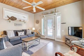 A living room with a sofa, coffee table, television, and a ceiling fan. - Casa Bella- Community Pool View | 0.3 mi to Beach (Port Aransas)