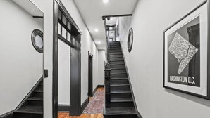 Un pasillo con una escalera que lleva a una plataforma. En la pared, hay un mapa enmarcado de Washington D.C.